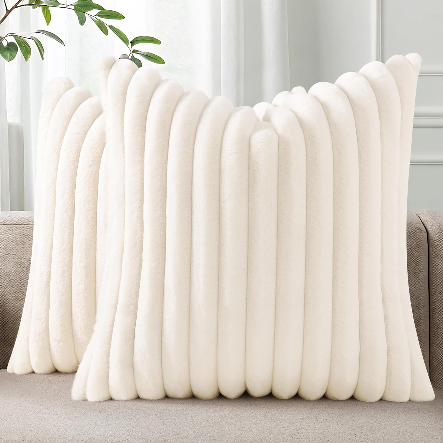 Pallene cream white faux fur striped throw pillow covers on a sofa